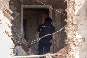 Rescuers work at the site of a Russian small-sized cruise missile “Banderol” hitting a private house