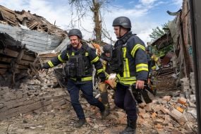 Rescuers work at the site of a Russian small-sized cruise missile “Banderol” hitting a private house