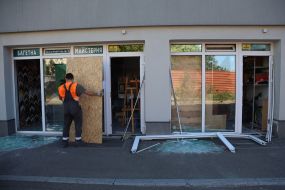 A man blocks a broken glass door with plywood after a rocket strike in Kyiv