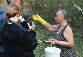 A resident of a damaged house gives an interview to journalists