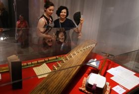 Visitors examine Japanese stringed instruments koto, shamisen and shakuhachi