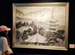 A visitor near Unemura Sekido's painting "Buddhist Temple in the Clouds"