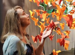 A visitor near paper cranes - a symbol of life, peace and faith in the best in Japan