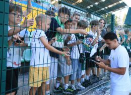 A player from FC Karpaty (Lviv) signs autographs for young fans.