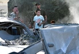 Девочка и мужчины осматривают полностью уничтоженные в результате массированной комбинированной атаки рф автомобили