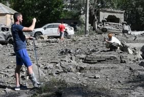 Люди оглядають руйнування після масованої комбінованої атаки рф у Солом'янському районі Києва