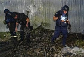 Police officers at the scene of the crash of a jet drone.