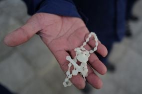 A prisoner of war holds a rosary with a cross in his hands of war in one of the special camps for holding Russian prisoners of war