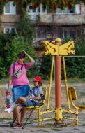 Мать сопровождает сына с травмой ноги в школу