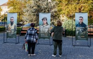Перехожі розглядають банери
