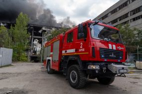 Пожежний автомобіль біля палаючої будівлі