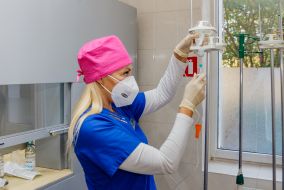 A laboratory technician prepares solutions for IV drips
