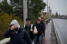 People are crossing the Pivdeny Bridge on foot