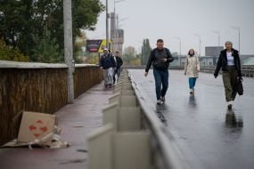 People are crossing the Pivdeny Bridge on foot