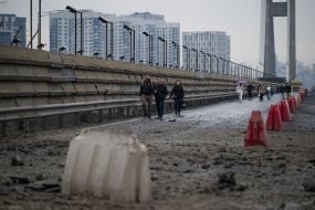 People are crossing the Pivdeny Bridge on foot