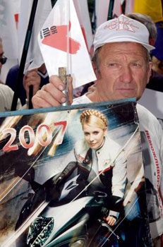 Активист БЮТ держит плакат с изображением лидера БЮТ Юлии Тимошенко, Харьков, 4 июля 2007 г.