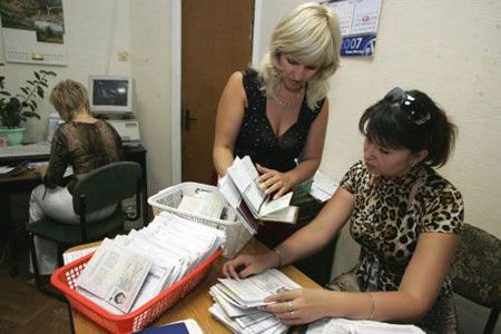 Старший інспектор ВГІРФО Донецького РВ УМВС України, старший лейтенант міліції Катерина Свірідова (праворуч) переглядає закордонні паспорти нового зразка