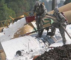 Сотрудники МЧС заливают пожарной пеной железнодорожные цистерны с желтым фосфором на месте техногенной аварии во Львовской области. 19 июля