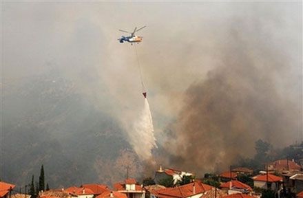Пожарный вертолёт над селом Маврики на юге Греции. (AP Photo)