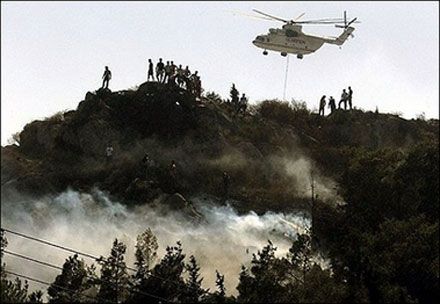 Пожарный вертолет сбрасывает воду на огонь у горы Гиметт, на юго-восток от Афин. (Photo AFP)