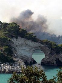 Огонь и дым близ г. Пескичи (полуостров Гаргано на Адриатическом побережье Италии), где сотни туристов и жителей вынуждены были оставить дома при приближении сильного пожара. (AP Photo)