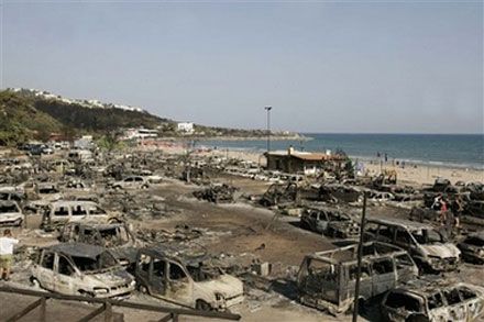 Сгоревшие машины в кемпинге Сан-Никола близ г. Пескичи (полуостров Гаргано на Адриатическом побережье Италии), где сотни туристов и жителей вынуждены были оставить дома при приближении сильного пожара; четыре человека погибли. (AP Photo)