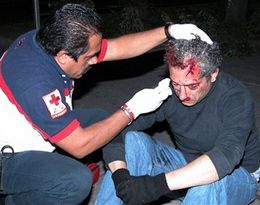 Хосе Луїсу Кальва надають допомогу медики: письменника збив автомобіль, коли він намагався втекти від поліції. Фото АР