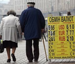 Пожилые люди проходят возле стенда с курсом валют. Киев, 27 октября