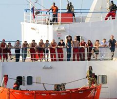 Члени команди захопленого піратами українського судна ”Фаїна” стоять на палубі корабля під наглядом піратів біля берегів Сомалі