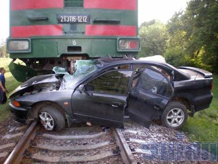 Розбитий автомобіль на залізничній колії