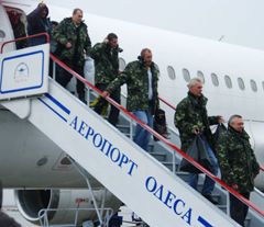 Члени команди звільненого з піратського полону судна «Аріана» спускаються по трапу літака, в Одесі. 6 січня 