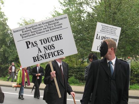 Надпись на плакате: “Европейская ассоциация предприятий, которые уклоняются от уплаты налогов: Не цепляйте наши прибыли!”