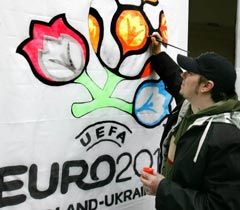 Художник розмальовує логотип УЄФА Євро-2012 флуоресцентними фарбами у Львові