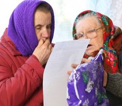 Женщины читают списки кандидатов в депутаты на одном из избирательных участков