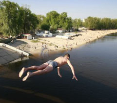 Хлопець стрибає у воду на одному з пляжів у Києві, 28 квітня