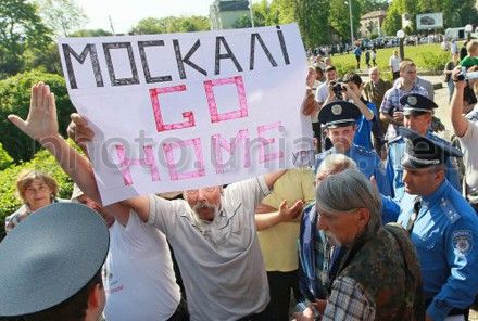 Чоловік тримає плакат з написом: ”Москалі – go homе” у Львові