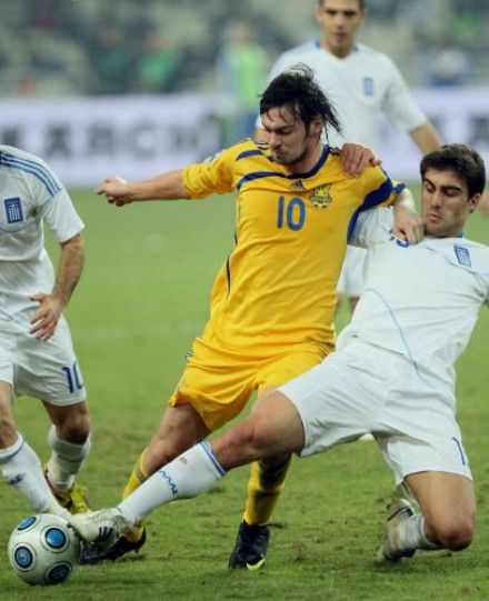 Артем Милевский и игрок сборной Греции ведут борьбу за мяч во время первого матча плей-офф за выход в финальную часть Чемпионата мира-2010 по футболу в Афинах , в субботу, 14 ноября 2009 г.