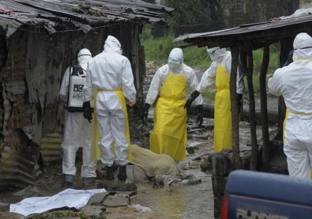 Либерийские медики готовятся убрать с улицы тело умершего от лихорадки Эбола, Либерия, 17 августа 2014 года / REUTERS