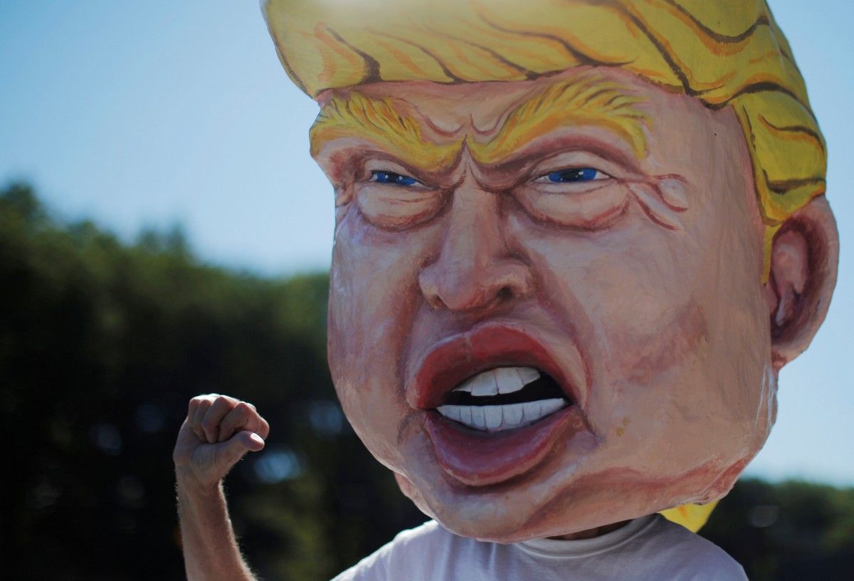 Противник Трампа с его головой из папье-маше / REUTERS Противник Трампа с его головой из папье-маше / REUTERS