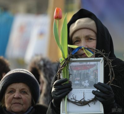 Женщина с портретом погибшего участника Майдана в терновом венке в Киеве, в среду, 26 февраля 2014 / УНИАН