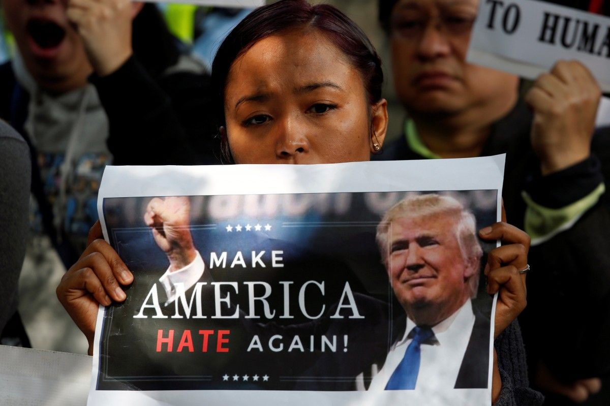 Участница акции протеста против указа Трампа / REUTERS Участница акции протеста против указа Трампа / REUTERS