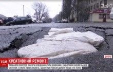 Украинские инновации: в Днепре ямы на дорогах закрыли мешками с мусором (видео)