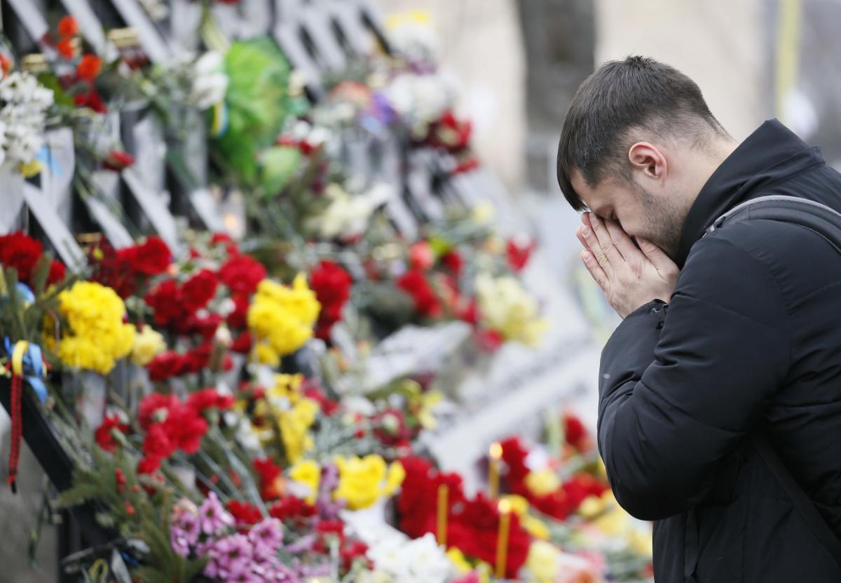 Мужчина у мемориала на Аллее Героев Небесной Сотне  / REUTERS/Valentyn Ogirenko