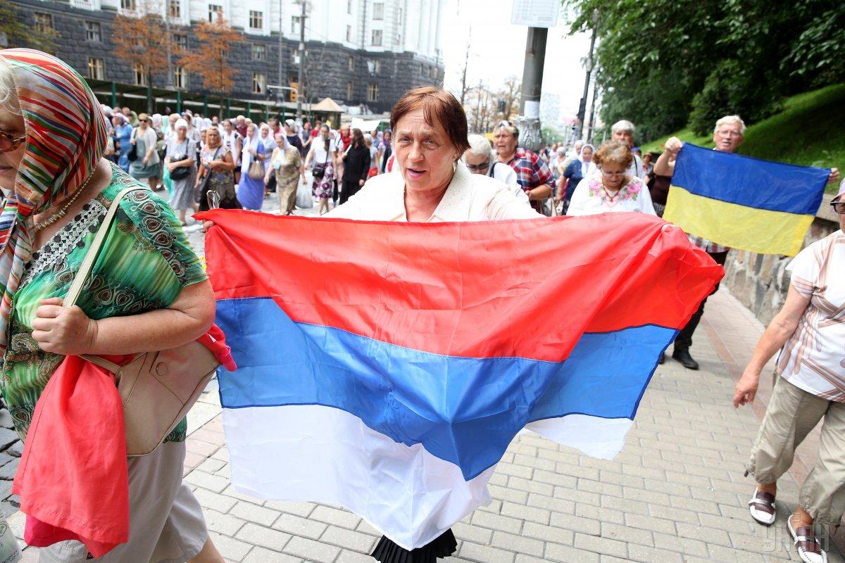 Женщина несет флаг России во время крестного хода в Киеве / УНИАН