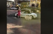 В центре Киева девушка разрисовала Porsche и изрубила его топором (видео)