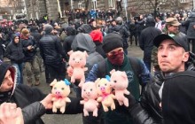 Учасники акції проти розкрадання в "оборонці" закидали правоохоронців іграшковими свинками (фото)