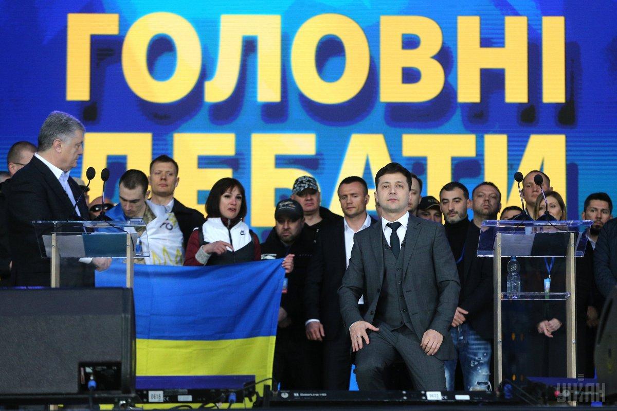 В знак уважения к родственникам погибших на Донбассе оба кандидата стали на колени на сцене «Олимпийского» / УНИАН