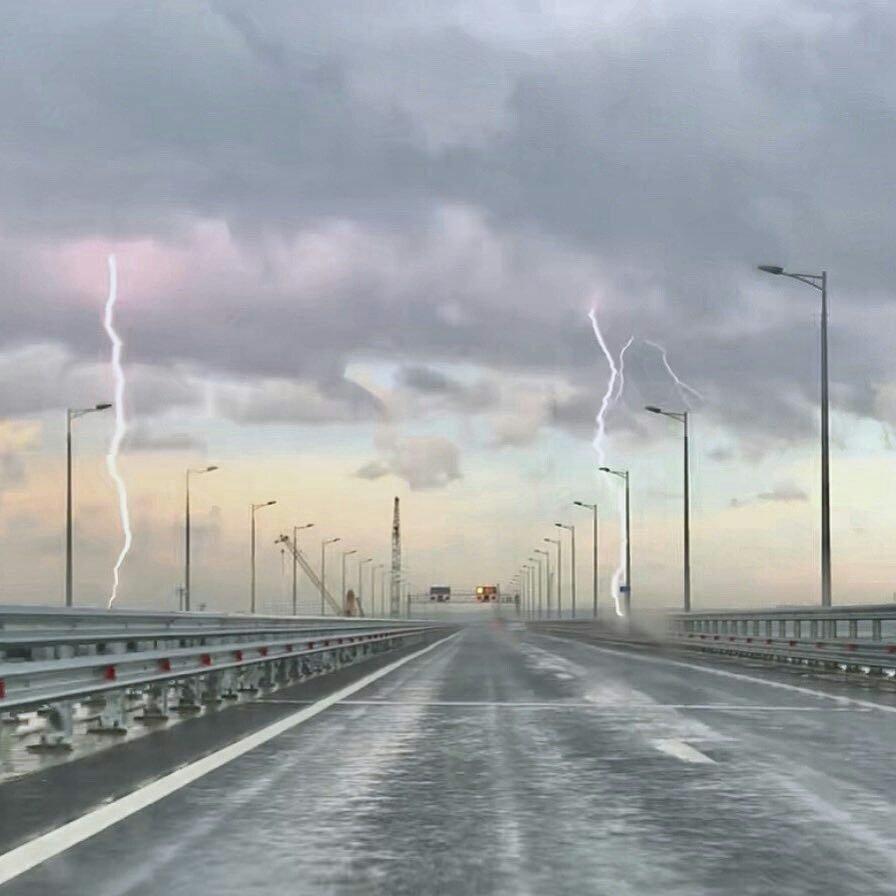 На фото видно, як в автомобільну частину мосту вдарили одразу дві блискавки / Kerchinfo На фото видно, як в автомобільну частину мосту вдарили одразу дві блискавки / Kerchinfo