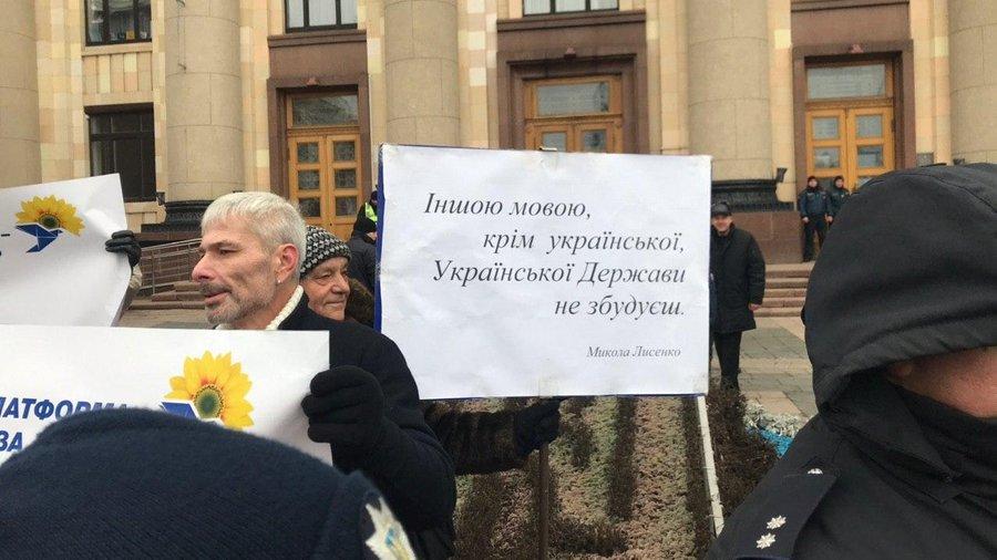 Противники акції "ОПЗЖ" (за оцінками кореспондента Суспільного, не менше 60 людей) тримали плакати: "Іншою мовою, крім української, Української Держави не збудуєш" / фото suspilne.media Противники акції "ОПЗЖ" (за оцінками кореспондента Суспільного, не менше 60 людей) тримали плакати: "Іншою мовою, крім української, Української Держави не збудуєш" / фото suspilne.media