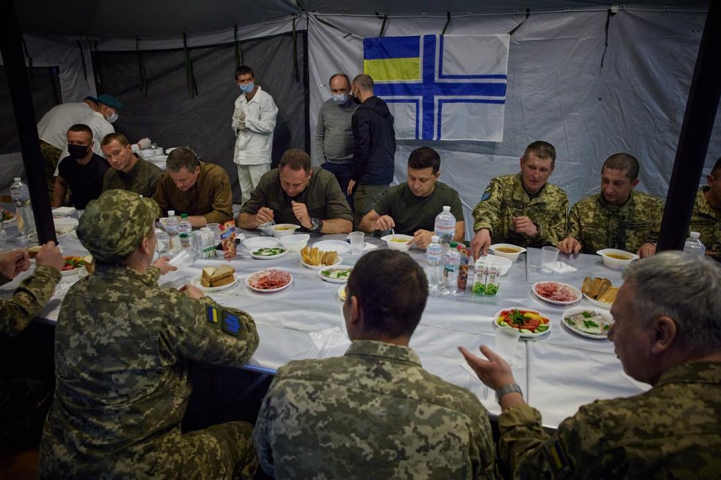 A group of men sitting at a table with food

Description automatically generated with medium confidence